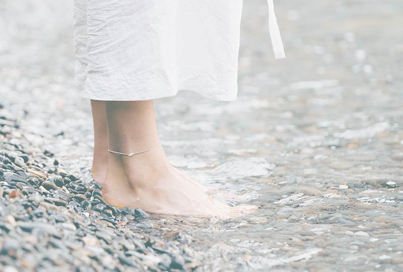 Seminare für Frauen: Füße auf einem Kiesstrand