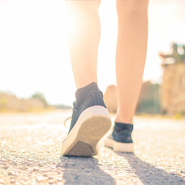 Seminare für Frauen: Frauenbeine auf Asphaltstraße, Sinnbild